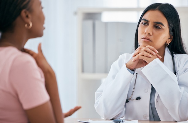 Doctor consulting with a patient about thyroid care, representing the integration of specialized care through Rouria's referral system.